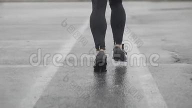<strong>运动鞋</strong>跑步者腿的慢动作镜头。 男运动员在<strong>户外</strong>慢跑。 多雨的单跑道